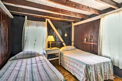 a bedroom with two beds and a table with a lamp at Beachfront Connecticut Retreat with Views! in Milford