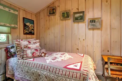 a bedroom with a bed and a wooden wall at West Dover Vacation Rental with Hot Tub Near Mt Snow in West Dover