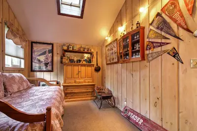 a bedroom with a bed and a wooden wall at West Dover Vacation Rental with Hot Tub Near Mt Snow in West Dover