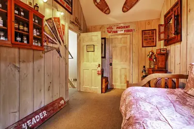 a bedroom with a bed in a room with wooden walls at West Dover Vacation Rental with Hot Tub Near Mt Snow in West Dover