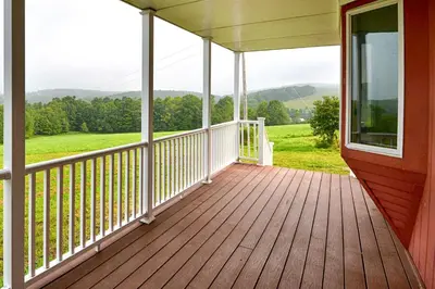 a porch of a home with a view of the mountains at Mountain Top Country Hideaway 48 Acres, Fire Pit! in Leonardsville