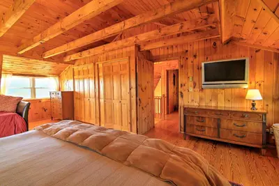 a bedroom with a bed and a flat screen tv at Bearpen Lodge on 125 Acres - Near Belleayre Mtn! in Vega