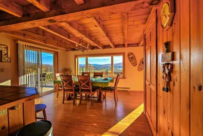 a dining room with a table and chairs and a large window at Bearpen Lodge on 125 Acres - Near Belleayre Mtn! in Vega