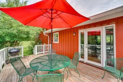 a table and chairs on a deck with a red umbrella at Hudson Valley Horse Farm Retreat in Salt Point in Salt Point