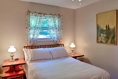 a bedroom with a bed and two nightstand tables at Mayfield Home with Private Dock on Lake Sacandaga! in Broadalbin