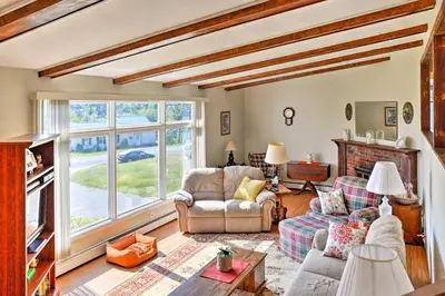 a living room with couches and a large window at Mayfield Home with Private Dock on Lake Sacandaga! in Broadalbin