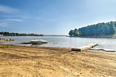 a boat is docked at a dock on a lake at Mayfield Home with Private Dock on Lake Sacandaga! in Broadalbin