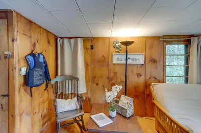 a bedroom with a bed and a wooden wall at Rustic Berkshires Cottage at Lake Buel with Kayaks! in New Marlborough