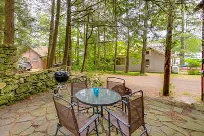 a glass table and chairs on a patio at Rustic Berkshires Cottage at Lake Buel with Kayaks! in New Marlborough