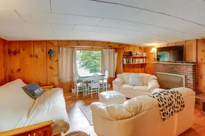 a living room with a couch and a table at Rustic Berkshires Cottage at Lake Buel with Kayaks! in New Marlborough