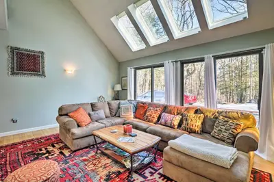 a living room with a couch and a table at Peaceful Goshen Cottage with Screened Porch and Views! in Goshen