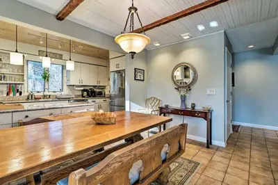 a kitchen with a wooden table and a dining room at Peaceful Goshen Cottage with Screened Porch and Views! in Goshen