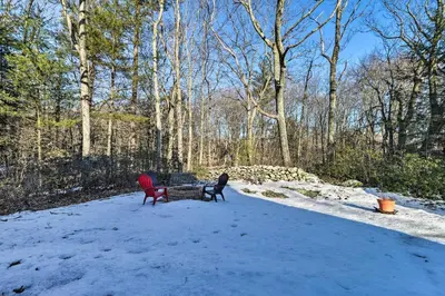 two benches sitting in the snow in a yard at Peaceful Goshen Cottage with Screened Porch and Views! in Goshen