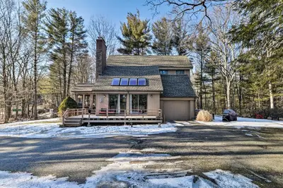 a house with a porch in the snow at Peaceful Goshen Cottage with Screened Porch and Views! in Goshen