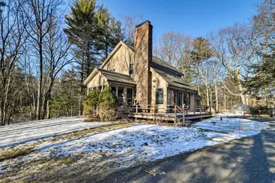 a house with snow on the ground in front of it at Peaceful Goshen Cottage with Screened Porch and Views! in Goshen