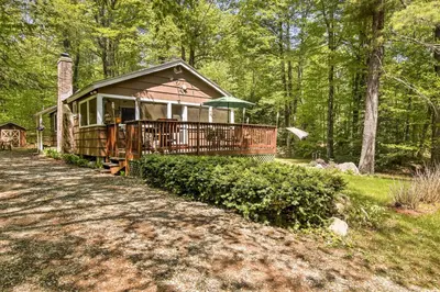 a small cabin in the woods with a porch at Pet-Friendly Cabin with Fire Pit, BBQ and Great Deck! in Williamsburg
