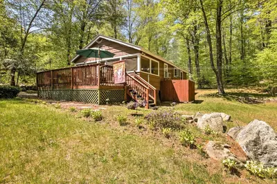 a cabin in the middle of a field with trees at Pet-Friendly Cabin with Fire Pit, BBQ and Great Deck! in Williamsburg