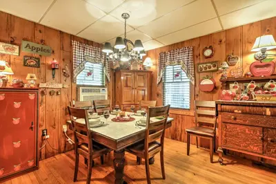 a dining room with a table and chairs and wooden walls at Pet-Friendly Cabin with Fire Pit, BBQ and Great Deck! in Williamsburg