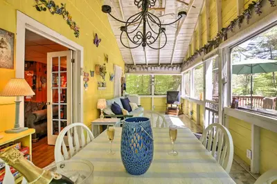 a dining room with a table with a blue vase on it at Pet-Friendly Cabin with Fire Pit, BBQ and Great Deck! in Williamsburg