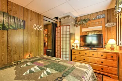 a bedroom with a bed and a tv on a dresser at Pet-Friendly Cabin with Fire Pit, BBQ and Great Deck! in Williamsburg