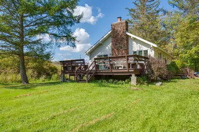 a house with a large deck on a grass field at Hunter Hideaway with Yard and Deck 3 Mi to Ski Slopes in Hunter