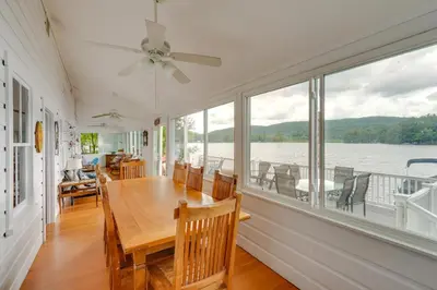 a dining room with a table and views of the water at Massachusetts Lake House with Dock - Pets Welcome! in New Marlborough
