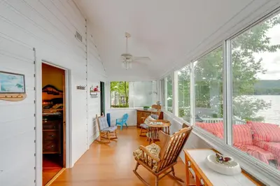 a living room with a table and chairs and windows at Massachusetts Lake House with Dock - Pets Welcome! in New Marlborough