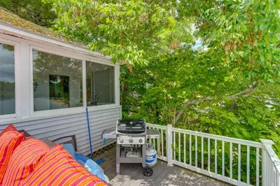 a porch with a grill and a chair on a house at Massachusetts Lake House with Dock - Pets Welcome! in New Marlborough