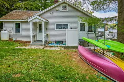 a house with two canoes in front of a house at Massachusetts Lake House with Dock - Pets Welcome! in New Marlborough