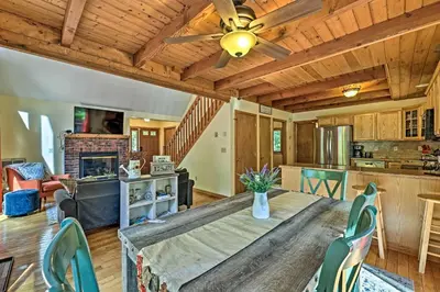 a kitchen and living room with a wooden ceiling at Mountain Cabin with Deck Near Year-Round Recreation! in Lake Ariel