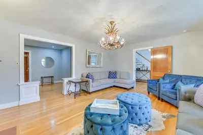 a living room with blue furniture and a chandelier at Slope Views Luxe Windham Retreat with Hot Tub! in Windham
