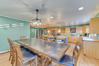 a large kitchen with a large wooden table and chairs at Slope Views Luxe Windham Retreat with Hot Tub! in Windham