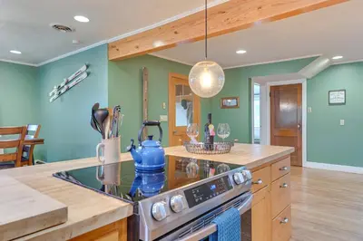 a kitchen with green walls and a stove top oven at Slope Views Luxe Windham Retreat with Hot Tub! in Windham