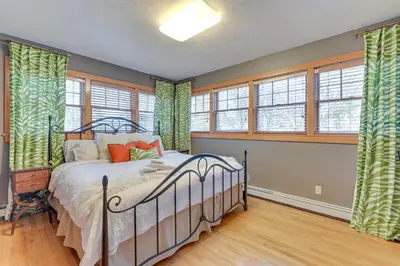a bedroom with a bed in a room with windows at Slope Views Luxe Windham Retreat with Hot Tub! in Windham