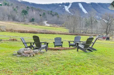 a group of four chairs and a table in a field at Slope Views Luxe Windham Retreat with Hot Tub! in Windham