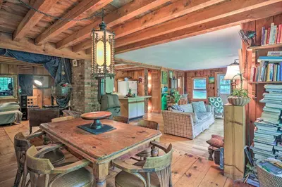 a kitchen and living room with a table and chairs at Berkshire Riverfront Ski Cabin Close to Hiking! in Mill River
