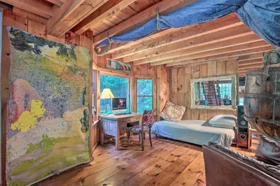a bedroom with a bed and a desk in a room at Berkshire Riverfront Ski Cabin Close to Hiking! in Mill River