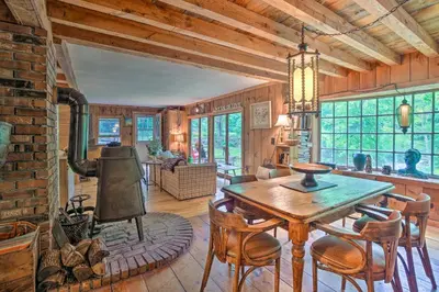 a dining room with a wooden table and chairs at Berkshire Riverfront Ski Cabin Close to Hiking! in Mill River