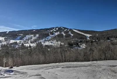 a snow covered hill with a mountain in the background at 4 Mi to Mount Snow West Dover Cabin with Game Room in West Dover