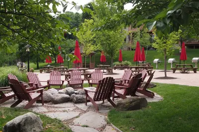 a group of chairs and tables with red umbrellas at Spacious Condo with View Less Than 1 Mi to Mtn Creek Resort! in Vernon Township