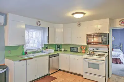 a kitchen with white cabinets and a stove top oven at Saratoga Springs Apt - Walk to Town and Race Track! in Saratoga Springs