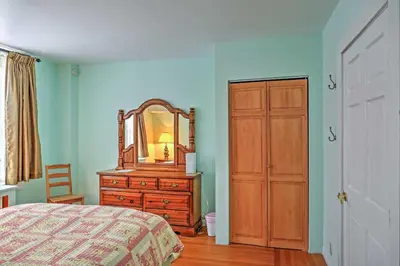 a bedroom with a bed and a dresser and a mirror at Saratoga Springs Apt - Walk to Town and Race Track! in Saratoga Springs