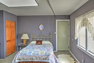 a bedroom with a bed and purple walls at Saratoga Springs Apt - Walk to Town and Race Track! in Saratoga Springs