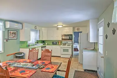 a kitchen with a table and chairs and a kitchen with white appliances at Saratoga Springs Apt - Walk to Town and Race Track! in Saratoga Springs
