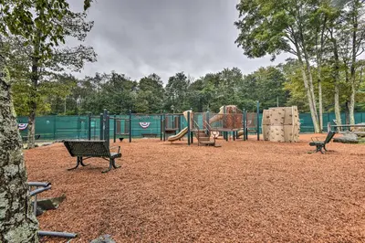 a park with a playground with benches and a slide at Pocono Mountain Home with 3 Community Lakes! in Gouldsboro