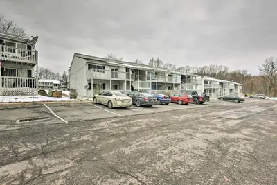 a parking lot with cars parked in front of a building at Near Mt Airy Casino Mount Pocono Condo with Balcony in Mount Pocono