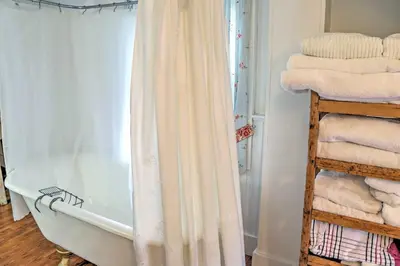 a bathroom with a shower curtain next to a bath tub at Dainty New Preston Cottage with Dock and Lake Views! in New Preston