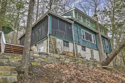 a green and white house with a tree at Dainty New Preston Cottage with Dock and Lake Views! in New Preston