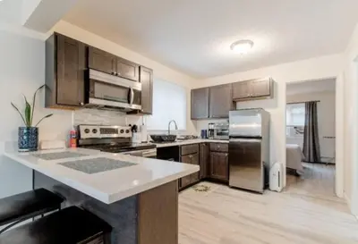 a kitchen with stainless steel appliances and wooden cabinets at Chic with Recliner at Webster Hill Suite 1W Request Xtra Bed in New Britain