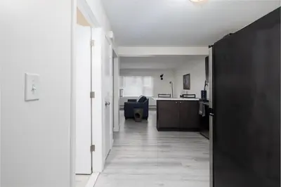 a hallway leading to a kitchen and a living room at Chic with Recliner at Webster Hill Suite 1W Request Xtra Bed in New Britain
